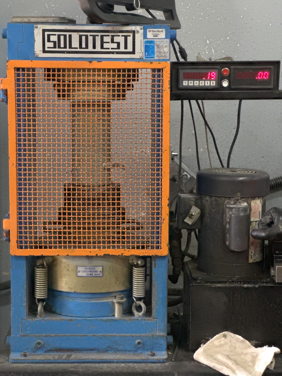 Prensa de ensaio de compressão com grade de proteção no laboratório da Geraltest