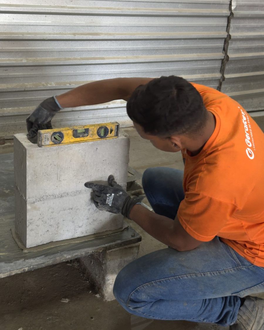 Técnico conferindo prumo de prisma de alvenaria em obra